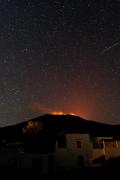 Foto notturna (dall'abitato di San Vincenzo) dell'attività eruttiva persistente ai crateri sommitali del vulcano Stromboli.